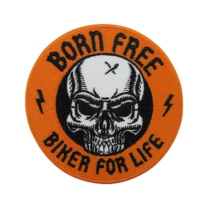May include: Orange round patch with black embroidered text that reads "Born Free Biker For Life". The patch features a black and white skull with a lightning bolt on each side.