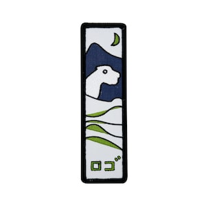 May include: White embroidered patch featuring a stylised image of a polar bear in a landscape with green hills and a blue mountain. The patch has a black border and the text "ロコ" in green.