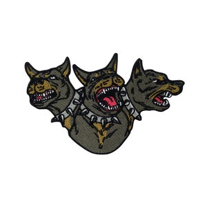 May include: An embroidered patch depicting a three-headed dog with a spiked collar. Each head is snarling with sharp teeth and is coloured black and brown.