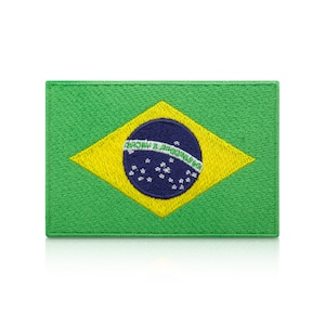 Pode incluir: Um remendo bordado representando a bandeira do Brasil. A bandeira tem um círculo azul com estrelas brancas no centro, rodeado por um losango amarelo sobre um fundo verde.