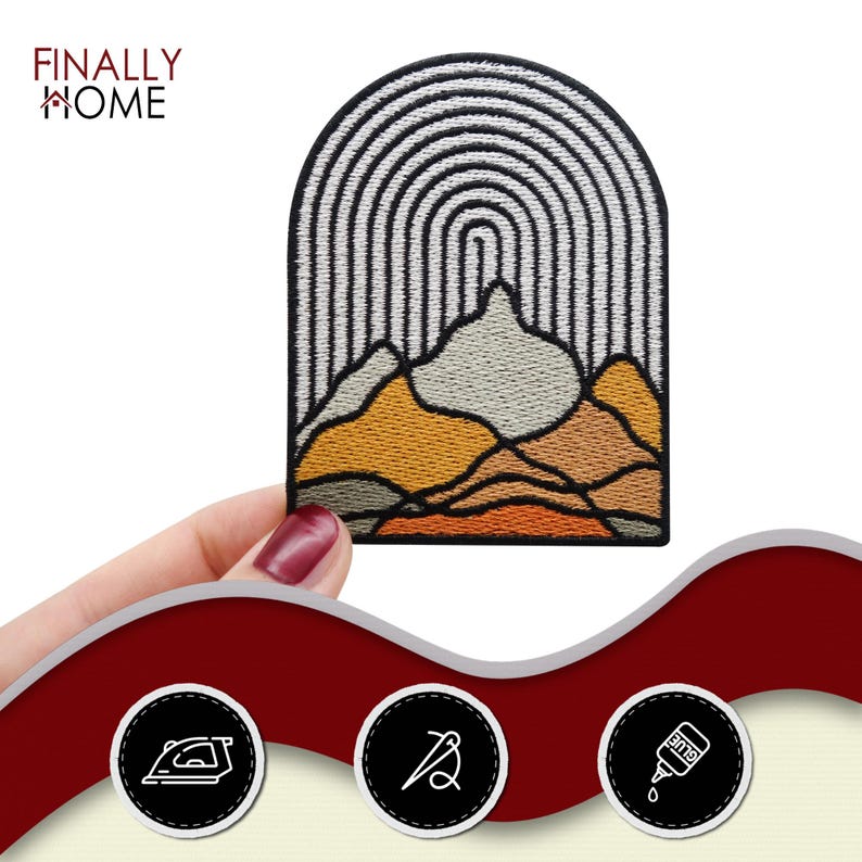 May include: An embroidered iron-on patch featuring a mountain range with an arched rainbow design in shades of orange, brown, and grey. The patch is outlined in black and has a white background.