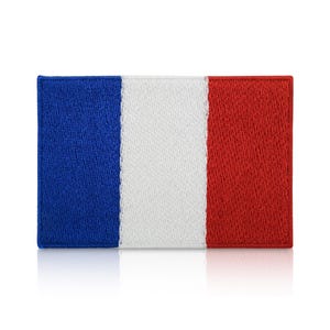 May include: Embroidered patch depicting the French flag. The rectangular patch has vertical stripes in blue, white, and red. The colours are vivid, and the stitching is detailed, giving a textured look. The patch is likely for clothing or accessories.