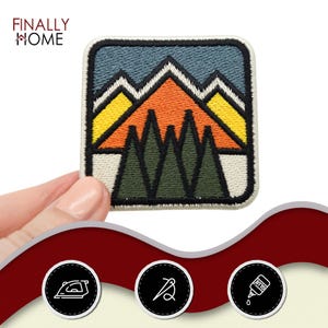 May include: A colorful embroidered patch featuring a mountain range with a sunset sky and pine trees. The patch is square and has a white background.