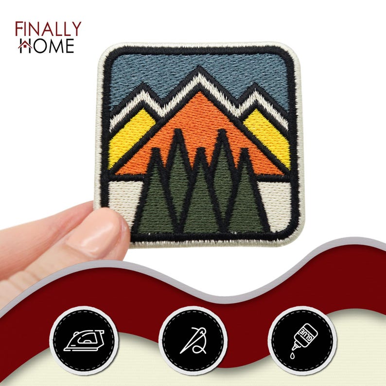 May include: A colorful embroidered patch featuring a mountain range with a sunset sky and pine trees. The patch is square and has a white background.