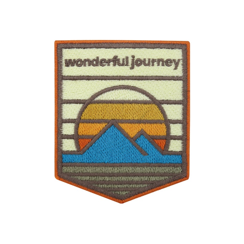 May include: An embroidered patch with a sunset scene and mountains. The patch is beige with orange, yellow, blue, and brown embroidery. The text "wonderful journey" is embroidered in brown at the top of the patch.