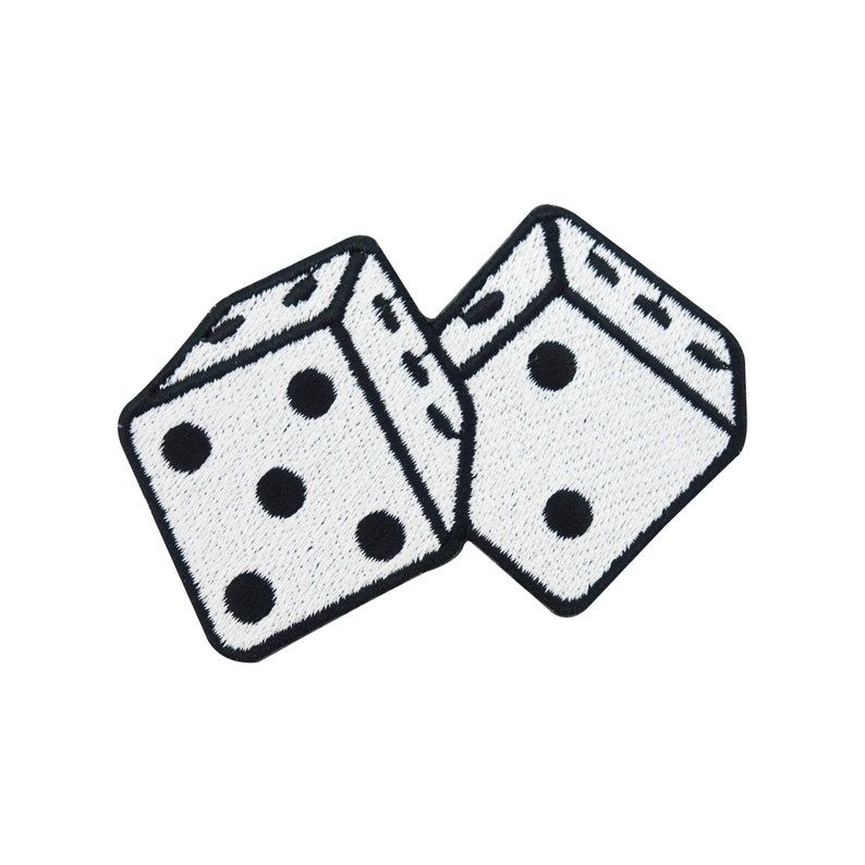 Pu&ograve; includere: Due dadi bianchi con punti neri, un dado &egrave; sdraiato sul lato e l'altro &egrave; in piedi. I dadi sono ricamati su uno sfondo bianco.