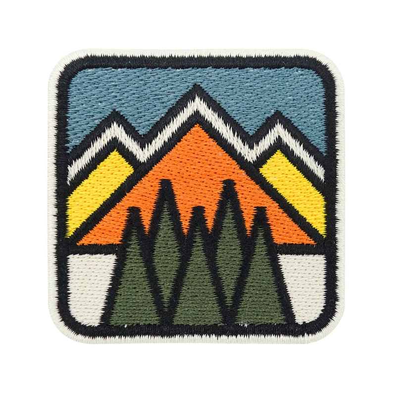 Geometrische Berge, dahinter blauer Himmel und im Vordergrund ein Wald, Rechteckiger Patch mit abgerundeten Ecken