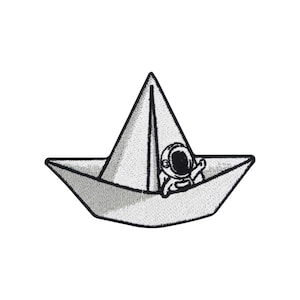 May include: Embroidered patch depicting a paper boat with an astronaut waving from within. The patch is mainly white and grey, with detailed stitching. The astronaut is wearing a spacesuit. The design is whimsical and suitable for clothing or accessories.