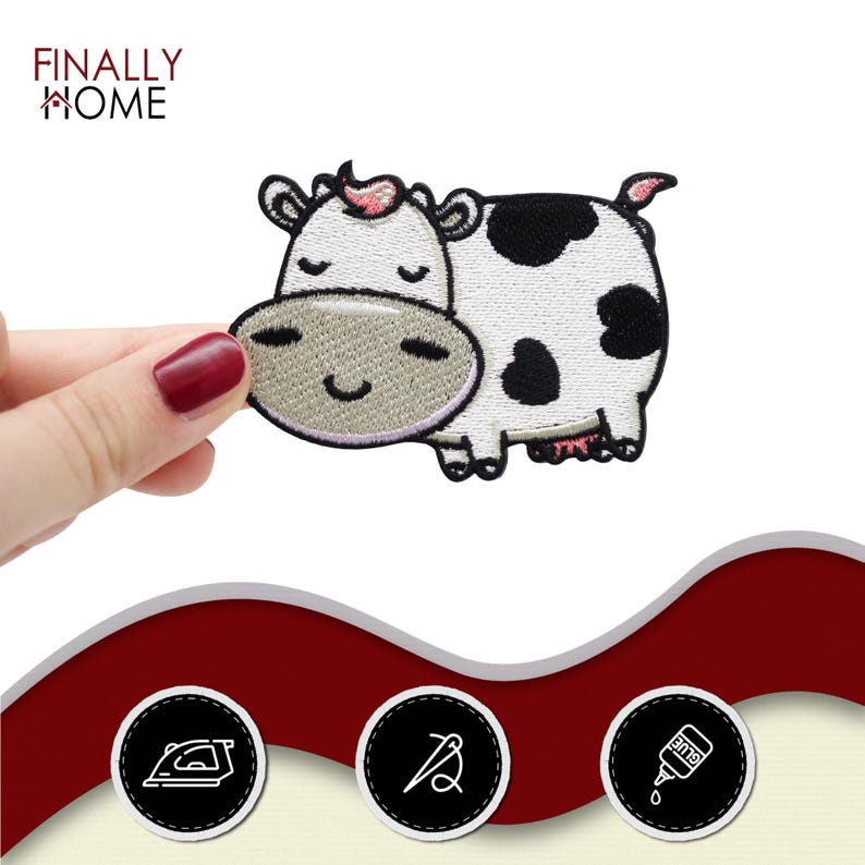 May include: Embroidered cow patch with a smiling face, black spots, and a pink tuft of hair. The patch is white with black spots and a light grey face. The text "FINALLY HOME" is in the upper left corner.