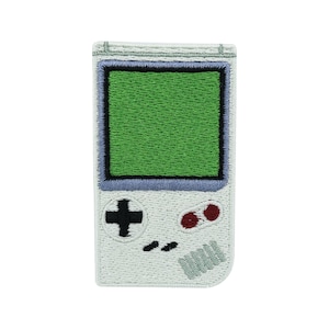 Peut inclure: Patch brodé blanc représentant une console de jeu vidéo portable avec un écran vert, des boutons noirs et des boutons rouges.
