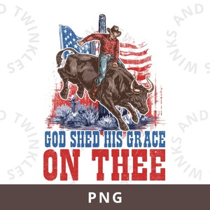 May include: A cowboy riding a bull in front of an American flag with the text "God Shed His Grace On Thee".