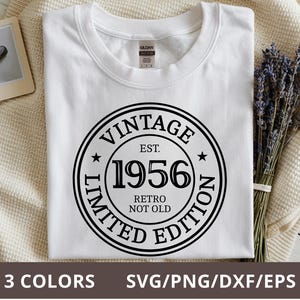 May include: White t-shirt with a black circular graphic that reads "VINTAGE EST. 1956 RETRO NOT OLD LIMITED EDITION." The shirt is on a cream-colored blanket with a bundle of lavender. The bottom of the image says "3 COLORS SVG/PNG/DXF/EPS."