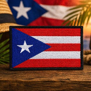 May include: Embroidered patch featuring the flag of Puerto Rico, with a blue triangle and white star on a red and white striped background. The patch is set against a tropical backdrop with a straw hat, hibiscus flower, and a lit lantern.