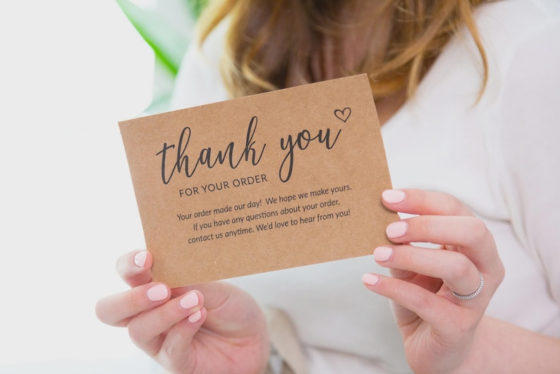Puede incluir: Una tarjeta de agradecimiento rectangular de papel kraft marr&oacute;n con texto impreso en negro que dice thank you FOR YOUR ORDER seguido de un mensaje sobre la satisfacci&oacute;n del pedido y datos de contacto con un peque&ntilde;o icono de coraz&oacute;n.