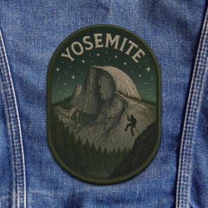 May include: An oval-shaped patch with the word "YOSEMITE" arched across the top. The patch features a detailed illustration of a mountain climber ascending a cliff face, with a forest and starry night sky in the background.