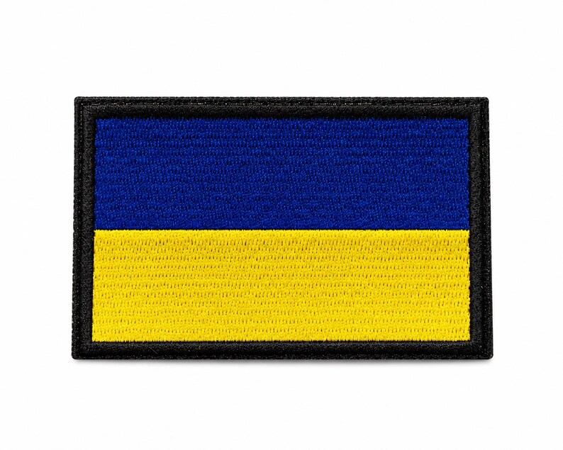May include: Embroidered patch featuring the flag of Ukraine. The rectangular patch has a blue upper half and a yellow lower half, with a black border. The colors are vibrant and the stitching is detailed.