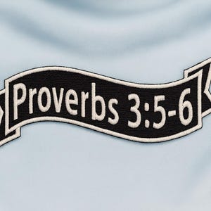 Könnte beinhalten: Ein schwarz-weißer, gestickter Aufnäher mit dem Text "Proverbs 3:5-6" in weißer Schrift. Der Aufnäher hat einen schwarzen Hintergrund mit weißer Schrift und einem weißen Rand. Der Aufnäher ist vor einem hellblauen Stoffhintergrund platziert.
