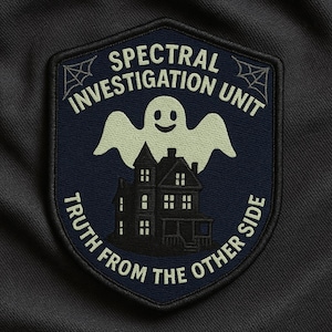 May include: A navy blue patch with the text "SPECTRAL INVESTIGATION UNIT" and "TRUTH FROM THE OTHER SIDE". The patch features a smiling ghost above a haunted house, with spiderwebs in the corners.