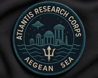 Peut inclure: Un écusson brodé circulaire bleu marine avec le texte "ATLANTIS RESEARCH CORPS" et "AEGEAN SEA" en crème. Le design comprend un trident, des vagues stylisées, des bâtiments et une soucoupe volante.
