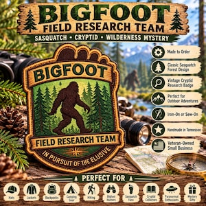 May include: A brown and green embroidered patch shaped like a footprint, featuring a silhouette of Bigfoot in a forest. The text reads BIGFOOT FIELD RESEARCH TEAM and IN PURSUIT OF THE ELUSIVE. The patch has a dark brown border.