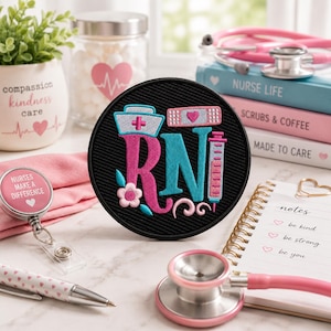 May include: A black RN patch featuring a nurse's hat, bandage, and syringe design in pink and teal. Medical supplies surround the patch, including a stethoscope, notebooks, and books titled "Nurse Life," "Scrubs & Coffee," and "Made to Care."