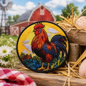 May include: A round embroidered patch featuring a colorful rooster with red, orange, blue, and black feathers. The patch is set against a yellow background with a farm scene in the background, including a red barn, windmill, and eggs.