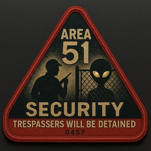 Può includere: Una toppa triangolare con bordo rosso e le parole "AREA 51 SECURITY" in oro. La toppa presenta una silhouette di una guardia e un alieno, con il testo "TRESPASSERS WILL BE DETAINED" e il numero "0457".
