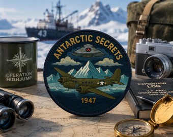 Peut inclure: Un écusson rond avec l'inscription "Antarctic Secrets" et une illustration d'avion vintage. Le design comprend un OVNI, des montagnes et l'année 1947. Autres éléments : une boussole, des jumelles, un appareil photo et une tasse avec "Operation Highjump".