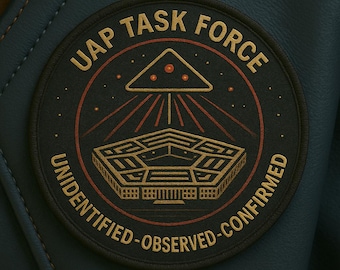 Peut inclure: Un écusson circulaire avec le texte "UAP TASK FORCE" et "UNIDENTIFIED-OBSERVED-CONFIRMED" en cercle. L'écusson présente un motif du Pentagone de couleur or avec des accents rouges et dorés, et un triangle avec trois points au-dessus.
