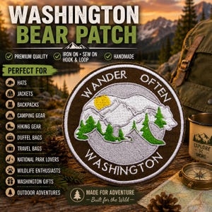 May include: A circular embroidered patch featuring a white bear silhouette filled with green pine trees and a yellow sun against a mountain backdrop. The brown border contains the white text WANDER OFTEN and WASHINGTON in a circular arrangement.