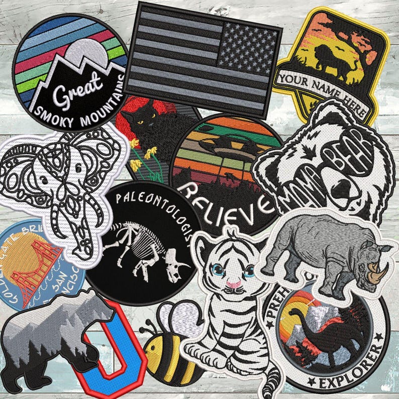 Puede incluir: Una colecci&oacute;n de parches bordados con diversos dise&ntilde;os, incluyendo un paisaje de las Great Smoky Mountains, una bandera estadounidense en blanco y negro, un le&oacute;n, un elefante, un gato negro, un OVNI, un esqueleto de dinosaurio, un oso, una abeja, un tigre y un rinoceronte.