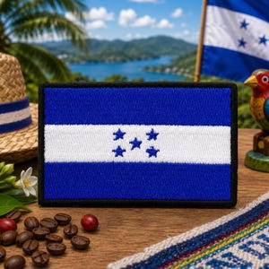 May include: A rectangular embroidered patch featuring the flag of Honduras, which consists of two horizontal blue stripes separated by a white stripe with five blue stars arranged in a pentagonal pattern, all bordered by a thick black edge.