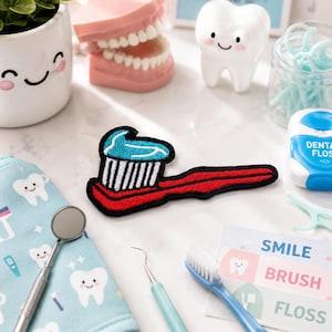 May include: A red toothbrush patch with blue toothpaste, surrounded by dental care items. Includes a model of teeth, a smiling tooth figurine, dental floss, and a blue toothbrush. A dental-themed patch.