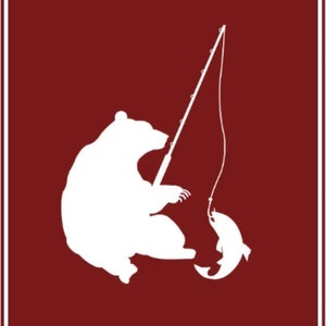 May include: A white silhouette of a bear fishing on a red background. The bear is sitting on its haunches with its paws outstretched, holding a fishing rod. A fish is on the hook at the end of the line. The text "HUNGRY BEAR DESIGNS" is at the top of the image.