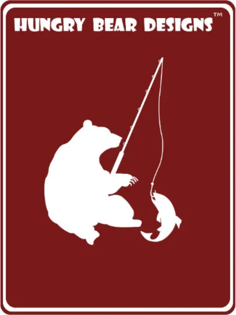 May include: A white silhouette of a bear fishing on a red background. The bear is sitting on its haunches with its paws outstretched, holding a fishing rod. A fish is on the hook at the end of the line. The text "HUNGRY BEAR DESIGNS" is at the top of the image.