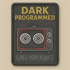 Könnte beinhalten: Ein rechteckiger schwarzer Aufnäher mit den Worten "DARK PROGRAMMED" in goldfarbenem Garn. Darunter befindet sich ein Retro-Fernsehdesign mit konzentrischen Kreisen und roter Umrandung. Der Aufnäher hat eine strukturierte Optik.