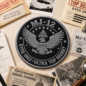 Op de afbeelding: Een zwart en grijs MJ-12-patch met een adelaarontwerp en tekst. De afbeelding bevat documenten met de labels "Classified" en "Top Secret", samen met een notitieblok, pen en vergrootglas, wat een thema van spionage suggereert.