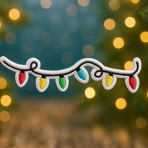 May include: Embroidered patch featuring a string of colorful Christmas lights. The lights are red, yellow, green, and blue, with a white outline and black cord. The patch is set against a blurred background of Christmas tree branches and bokeh lights.