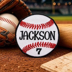 May include: A white baseball patch with red stitching and the name "JACKSON" in black lettering. The number "7" is below the name. The patch is on a baseball field with a baseball, glove, and bat.