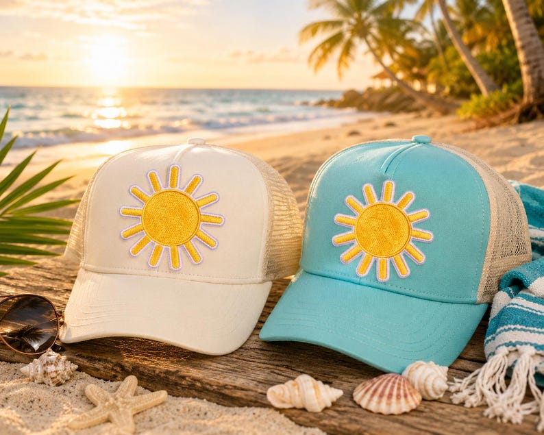 Puede incluir: Dos gorras tipo trucker, una color crema y otra azul claro, cada una con un parche de sol amarillo con borde violeta claro en el panel frontal. Ambas gorras cuentan con una parte trasera de malla y una visera curva en el dise&ntilde;o.