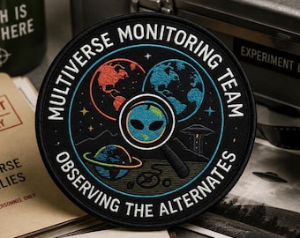 Può includere: Una toppa circolare ricamata nera con il testo MULTIVERSE MONITORING TEAM e OBSERVING THE ALTERNATES. Il design include tre pianeti, una lente d'ingrandimento con un volto alieno, un piccolo UFO e stelle su uno sfondo scuro.