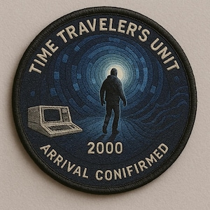 May include: Circular patch with the text "TIME TRAVELER'S UNIT" and "ARRIVAL CONFIRMED 2000." The patch features a person walking towards a bright light, a computer, and a blue tunnel design.