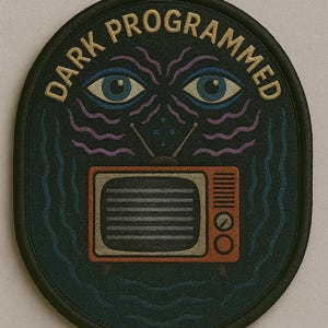 Pode incluir: Remendo oval com as palavras "DARK PROGRAMMED" em letras douradas. O remendo apresenta uma televisão retrô, dois olhos azuis e linhas onduladas roxas. O fundo é azul escuro.