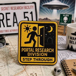 Op de afbeelding: Een vierkante geborduurde patch met een gele rand en een zwarte achtergrond. Het toont een geel silhouet van een persoon die door een deuropening loopt, een zon, een maansikkel en sterren. De tekst luidt: PORTAL RESEARCH DIVISION en STEP THROUGH.