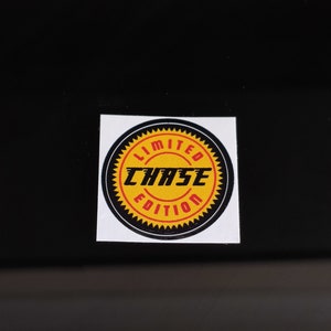 May include: A black and yellow sticker with the text "LIMITED EDITION CHASE" in red and yellow lettering.