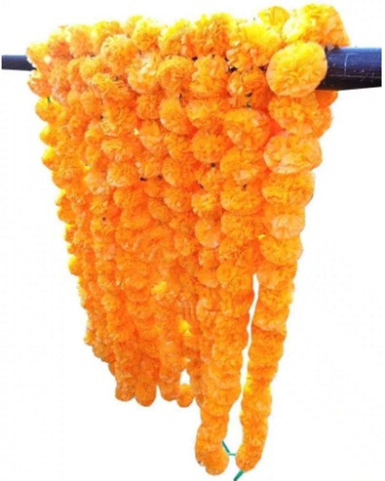 May include: A long garland of bright orange marigold flowers strung together. The garland is made of artificial flowers and is perfect for decorating for a festival or special occasion.