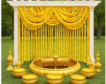 Puede incluir: Un arco de boda de madera blanca adornado con hileras de flores de caléndula amarillas. La escena incluye cuencos dorados, jarrones decorativos y una pequeña mesa, todo sobre un césped verde, creando un ambiente vibrante y festivo.
