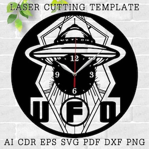 May include: Black and white laser cut clock design featuring a UFO with a clock face inside. The clock face has Roman numeral markings and the words "UFO" are displayed below the clock face.