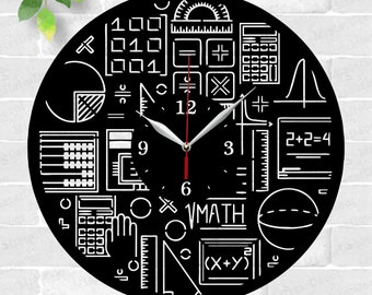 May include: Black and white laser cut clock design featuring various math symbols, equations, and a calculator. The clock face has a black background with white numbers and hands. The text "VMATH" is included on the clock face.