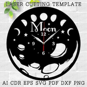 May include: Black and white laser cut clock design featuring a moon with phases and the word "Moon" with a star above it. The clock face has Roman numerals and a star design around the edge.